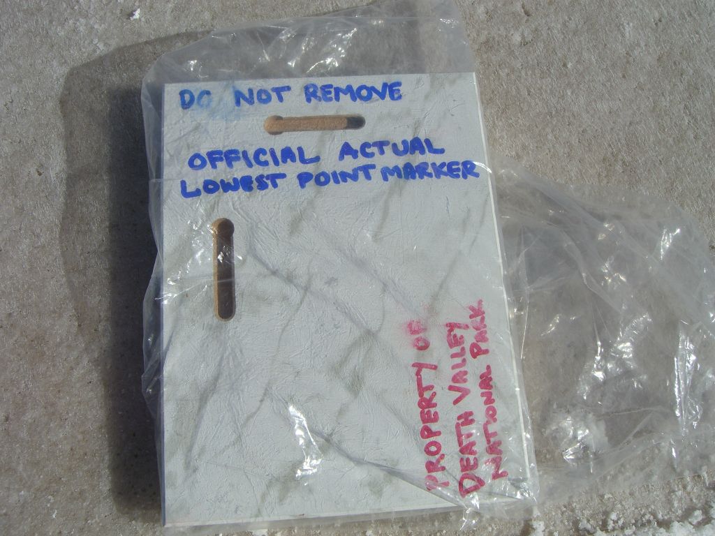 Putting the Lowest Point plaque back on the ground for the next group.  Keep in mind, the plaque has long since washed away and is no longer here: