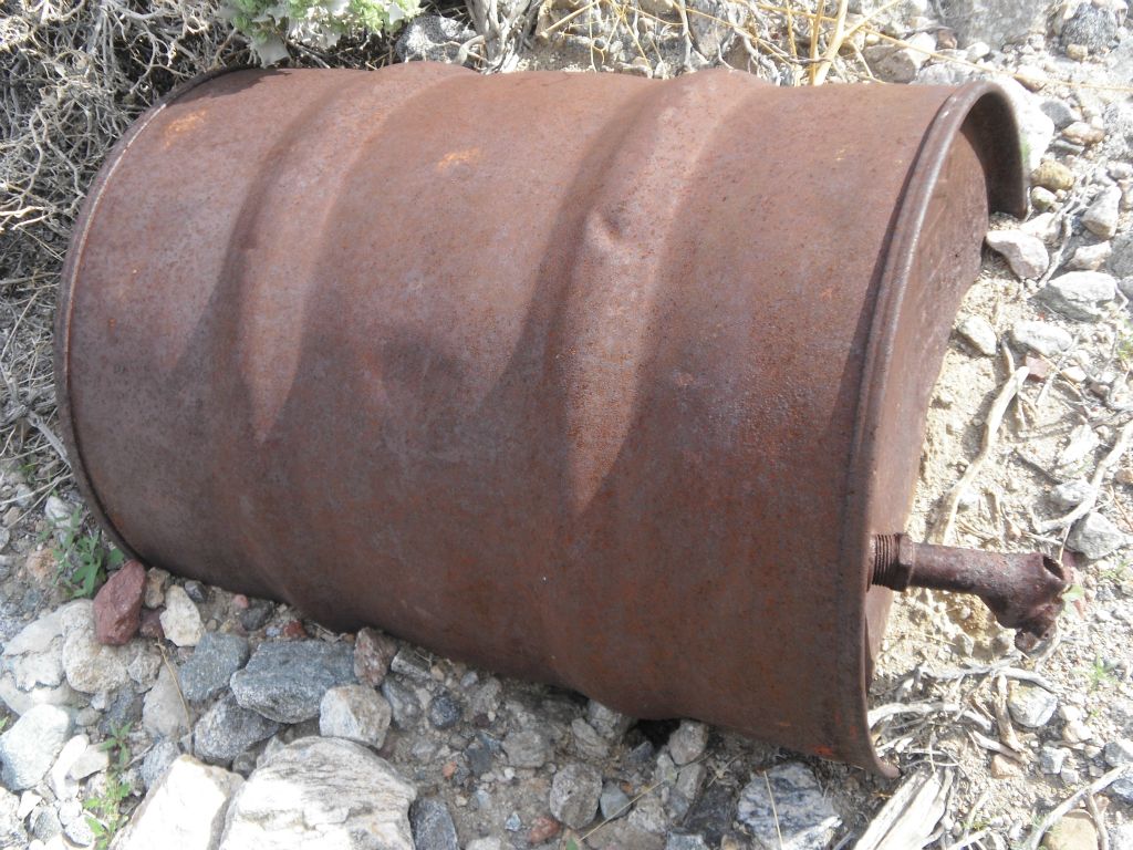 This rusted barrel container is slowly being buried in the gravel of the wash: