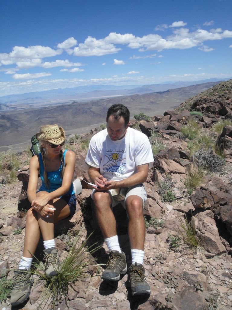 Steve signing in to the summit register as Daria looks at what he is writing: