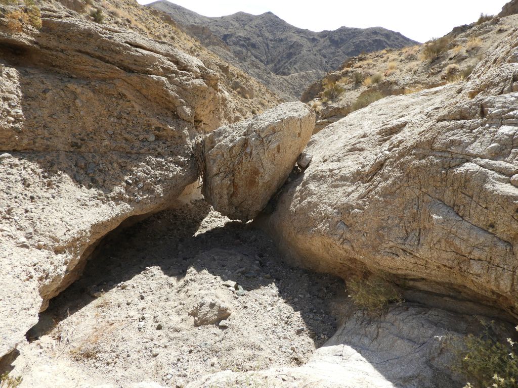 A boulder has rolled down the hillside here and gotten lodged right in the middle of the wash: