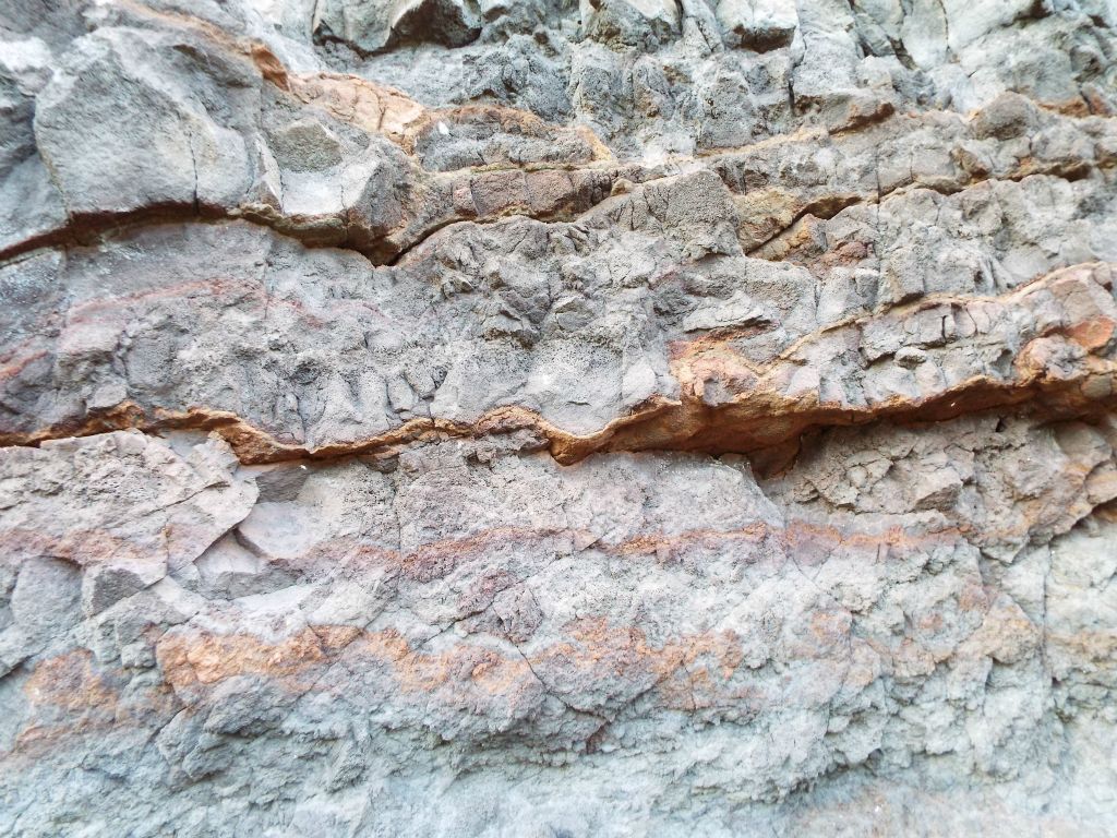 Notice the vivid red and orange-colored patterns along the rock wall: