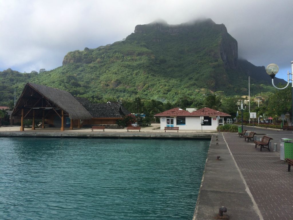 The airport ferry drops visitors to the main island of Bora Bora off at this dock.  In the background, the mountain peaks are currently fogged in near the top: