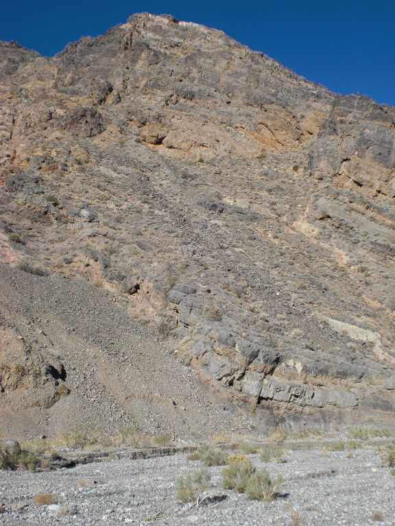High mountain slopes off to the side with a rockslide area: