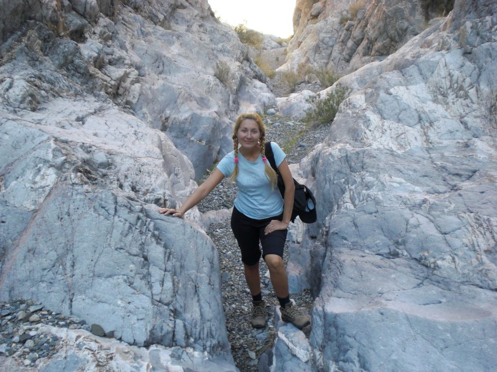 Daria posing next to the polished rock of a small passage: