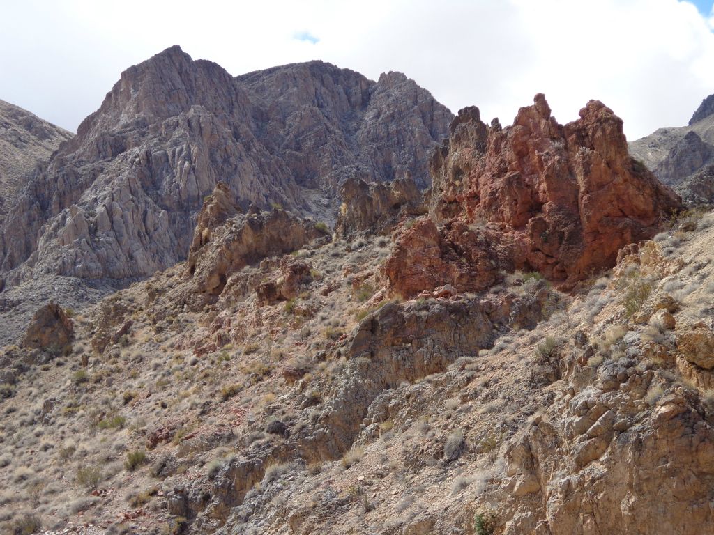Looking back at the red rock formation framed against the background peaks:
