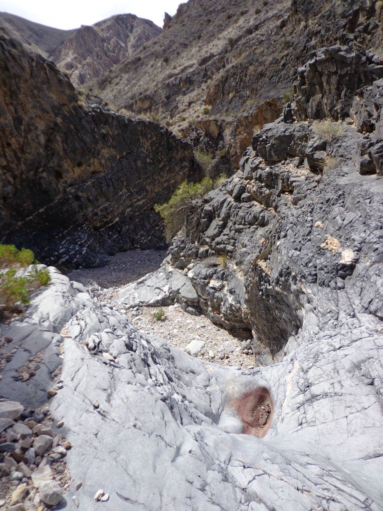 Looking down the narrow twisty canyon from the top of a dry fall: