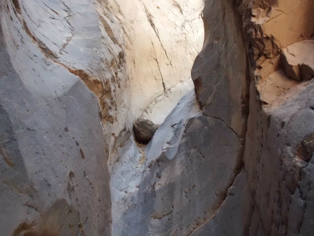 Dropping down a small polished dry fall with a boulder wedged in the center: