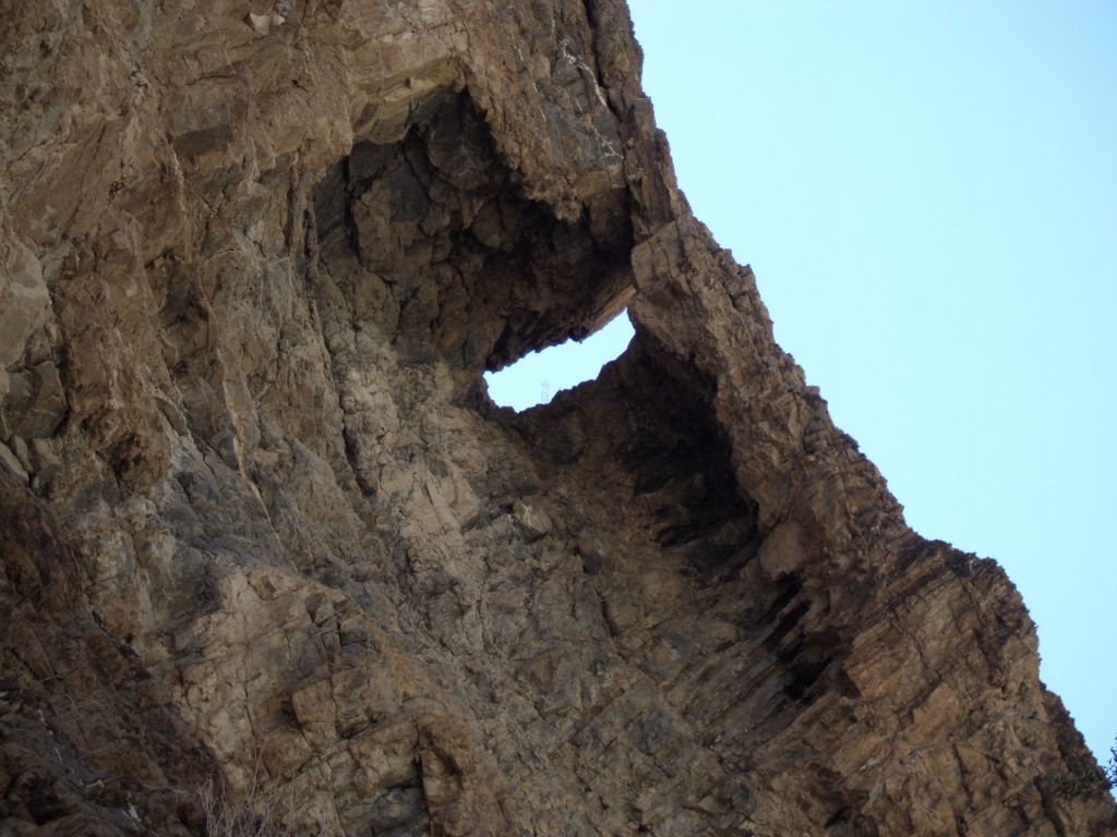 An opening in the rock wall high above the canyon floor: