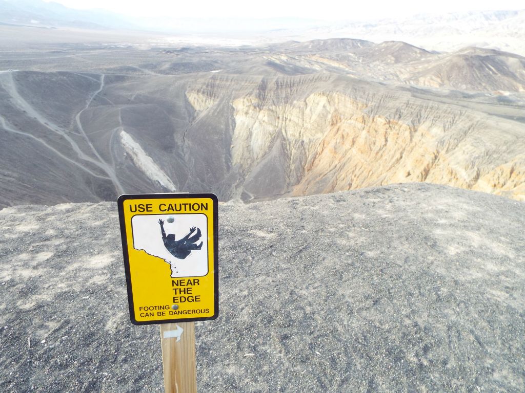 Warning signs remind tourists to keep a safe distance from the edge of the crater rim: