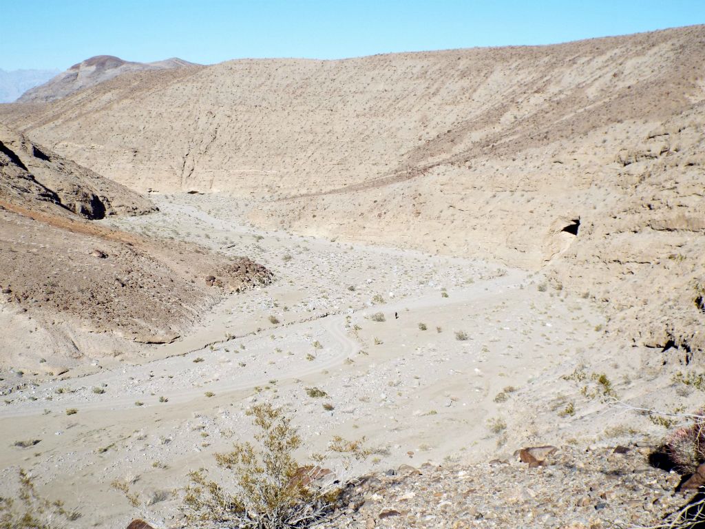 By looking to the northeast while climbing up, the Cottonwood Canyon cave is clearly visible.  If you look closely, my sister Tiffany is also visible walking toward the cave: