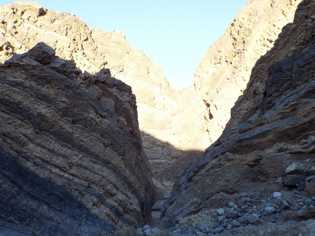 A very narrow passage visible just ahead between the two walls: