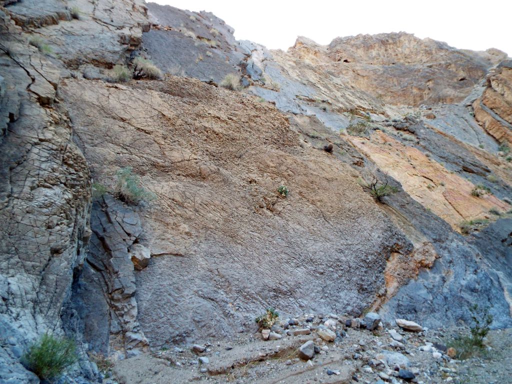 A closer look at some of the unique colorful rock slabs rising high above the wash: