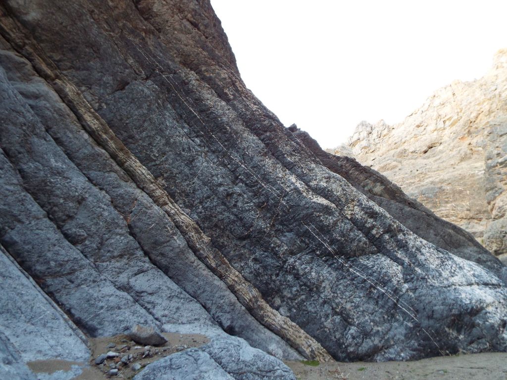 Just outside of the slot passage, the left side canyon wall sloped down with streaks and splotches of white: