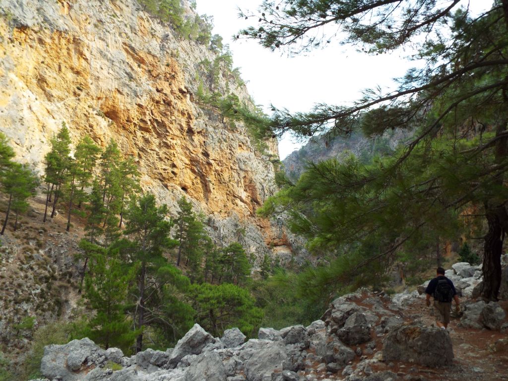Gary hiking along the Agia Irini Gorge trail with some colorful rock high up on the left side:
