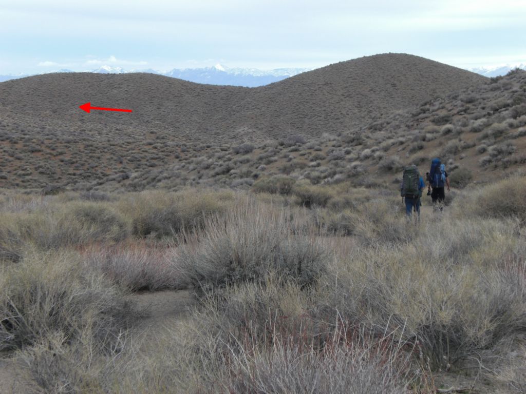 Soon, we emerged into a somewhat open area.  When you reach the base of the small hill with two bumps in the distance, you need to turn left to crossover into Dead Horse Canyon.  Turning right here will take you toward a canyon with impassable dry falls: