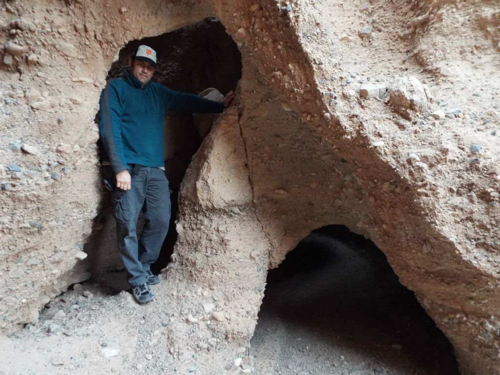 This picture of me reveals that the left side natural bridge opening is about 7 feet tall and the right side is about 4 feet tall: