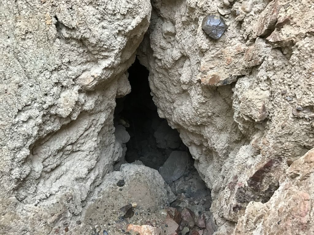 Two views showing the backside opening from the hillside drainage just above it: