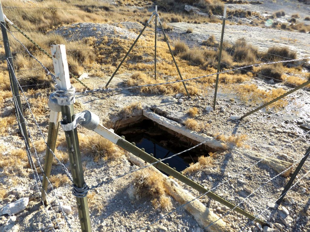 This fenced off area looks like it contains a flooded vertical mine shaft: