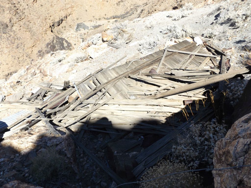 A totally collapsed wooden structure that likely once served as housing for miners: