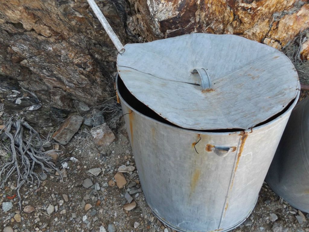 This metal bucket appears to have been set up to receive water being piped down from above: