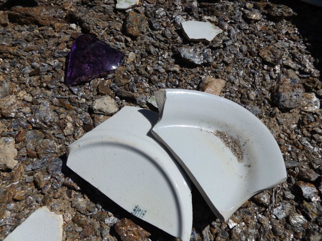 Broken china plates and colored glass pieces leftover from the time when miners lived, worked, and ate meals here: