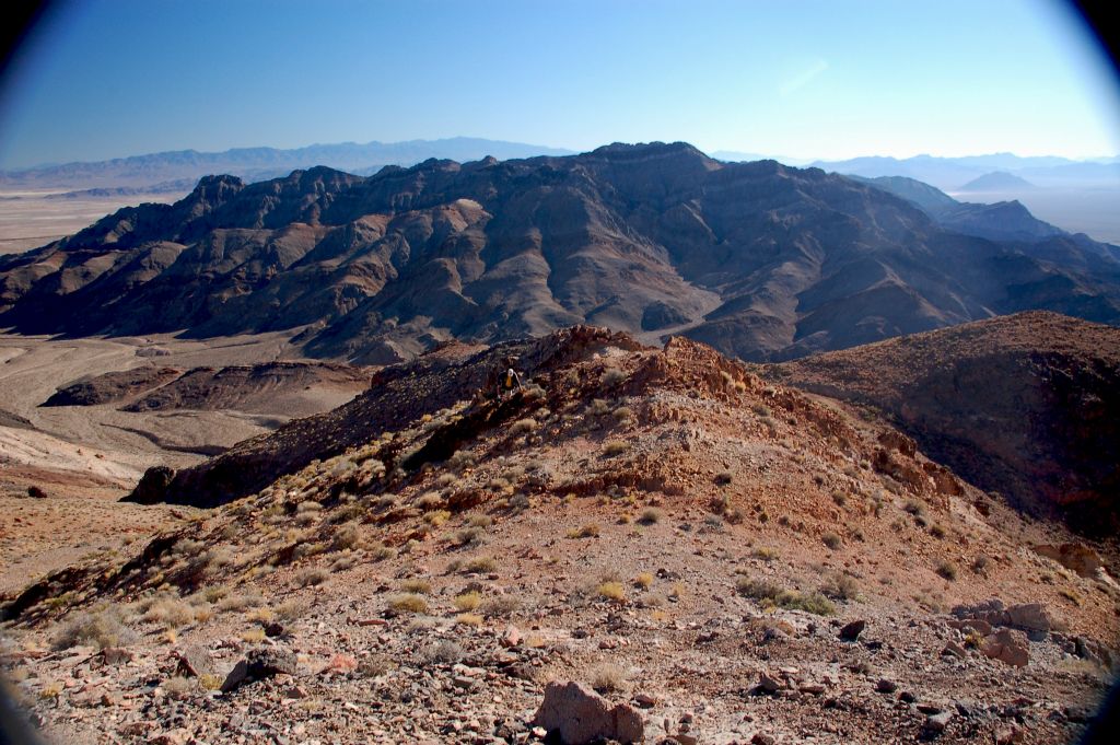Steve climbing over a mini-bump with the Funeral Mountains Wilderness Area in the background: