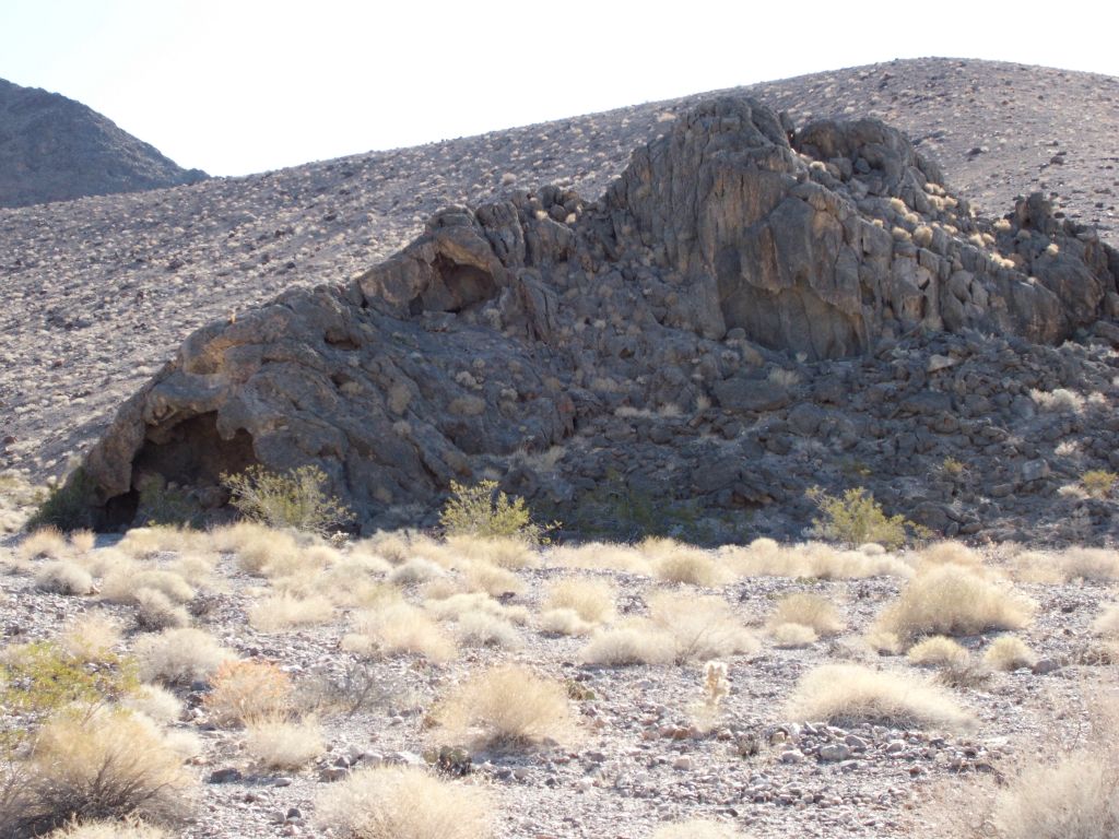 Three views of Strange Place, a triangular shaped rock formation with a cave like entrance: