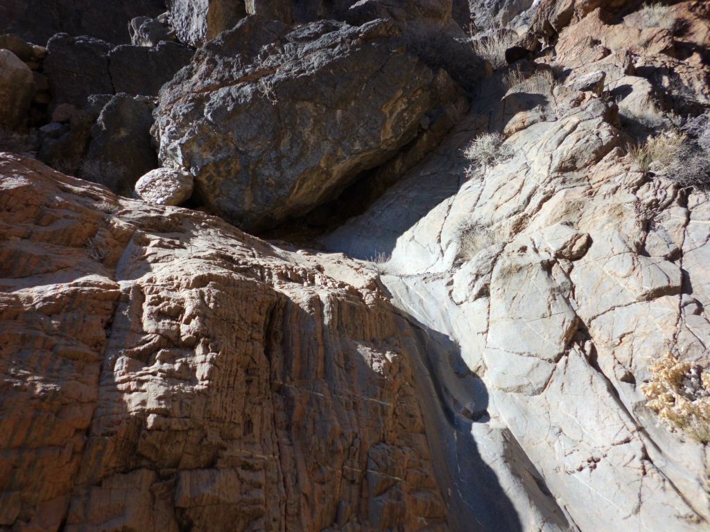 Climbing a polished chute in the midst of multi-colored rock: