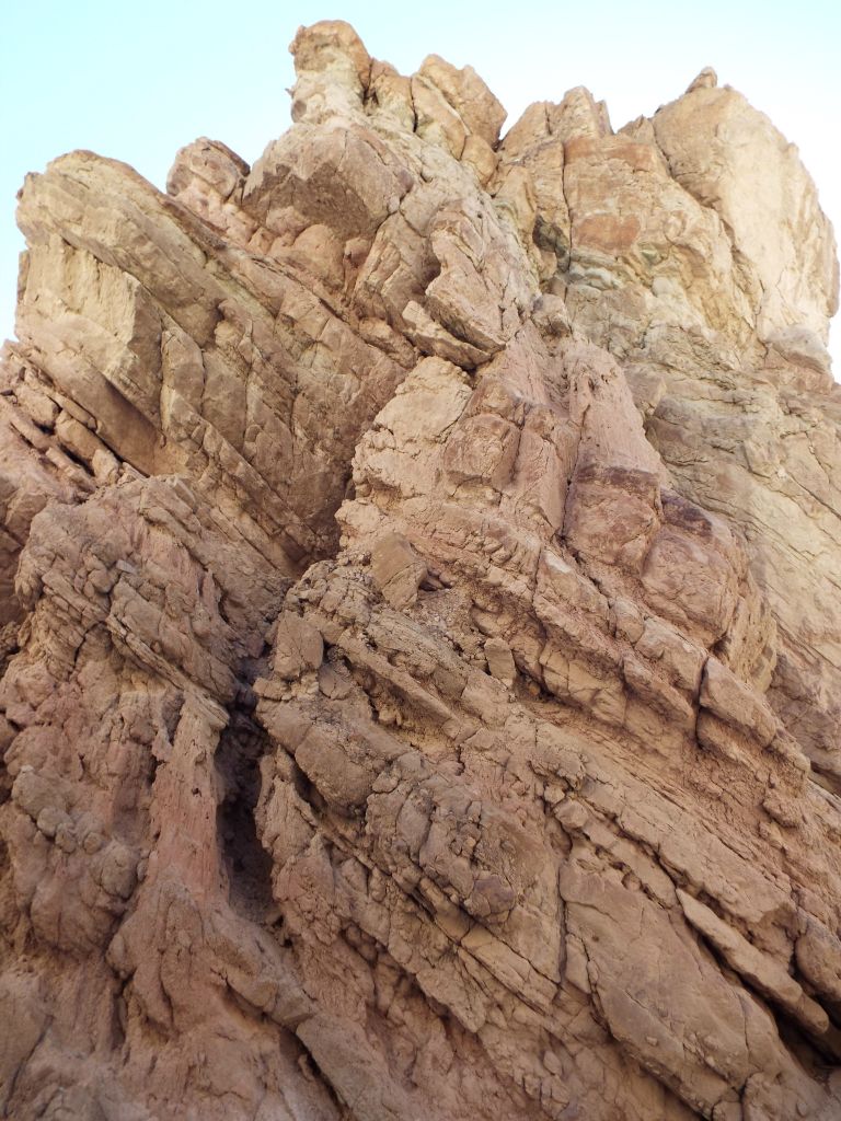 A truly towering canyon wall with odd shapes and designs all the way up: