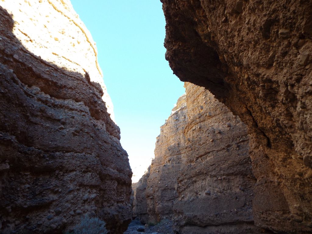A high dark overhang on the right side and bright sunshine on the upper left side canyon wall:
