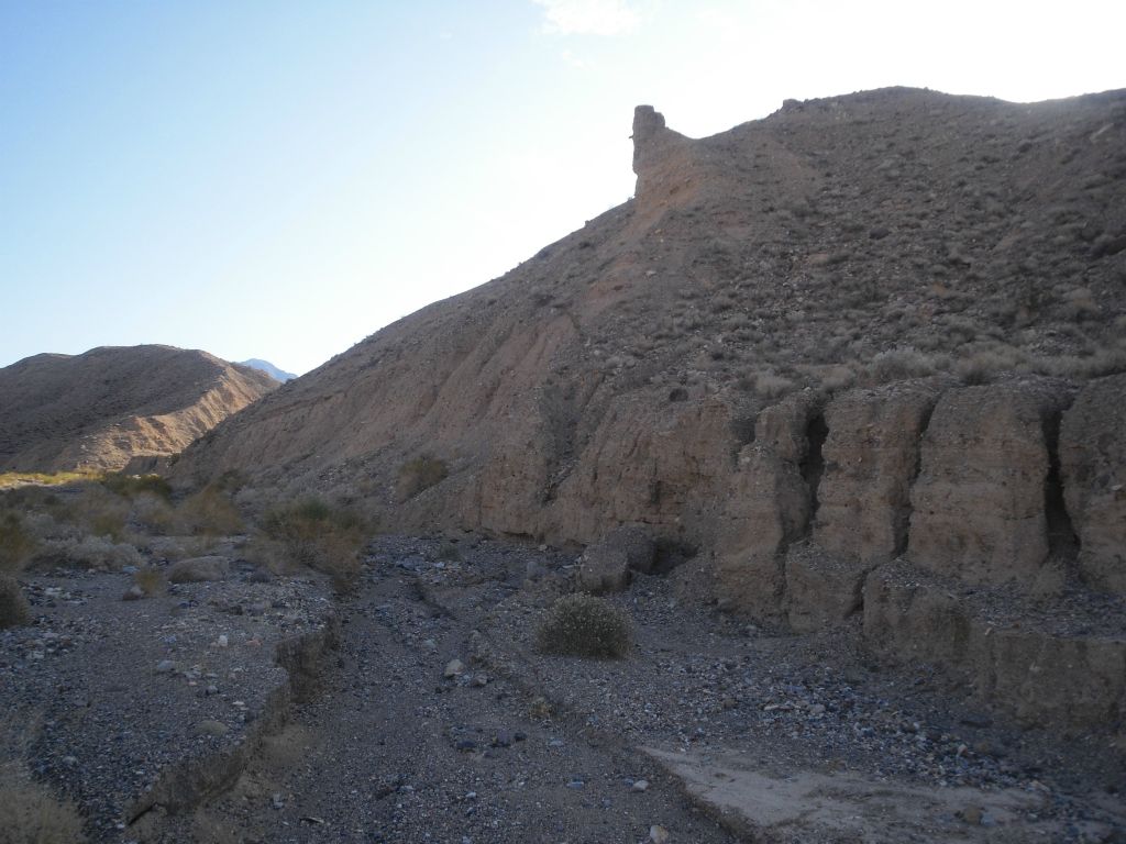 Conglomerate rock hillsides form along the way on both sides of the wash: