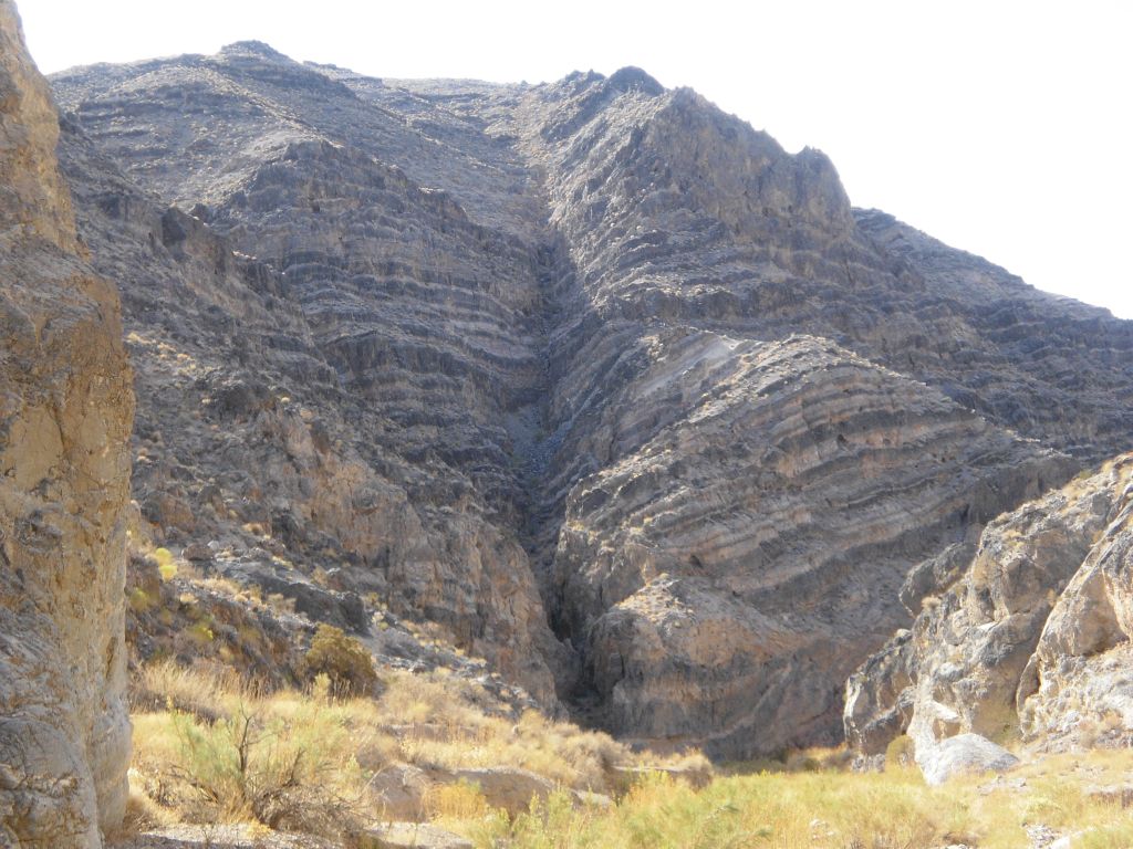 Notice how the multi-colored bands of rock extend far up the mountain:
