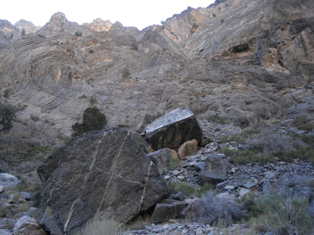 These two boulders appeared to have been carved out of the mountain in the distance (notice the square cave on the upper right) through natural forces and then rolled down into the wash: