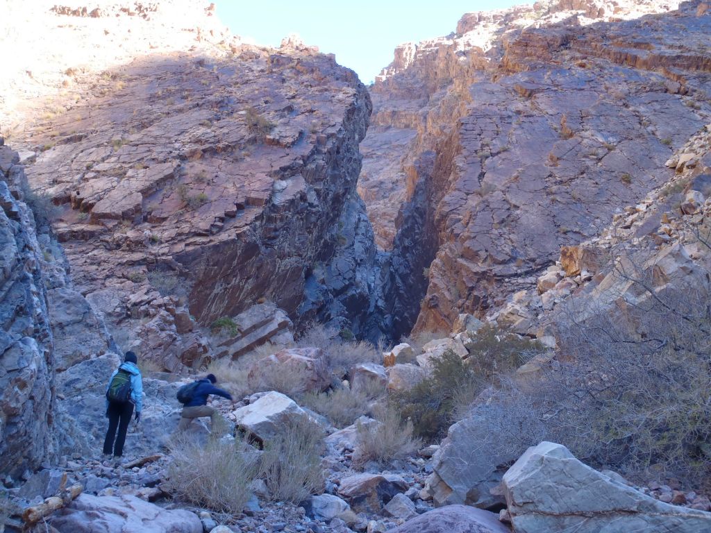 Steve is stepping over a rock as he heads toward the narrows and 1st dry fall: