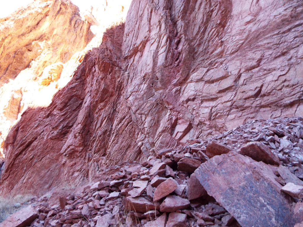 A beautiful wall of red with a landslide of fallen rocks which have broken off over the years: