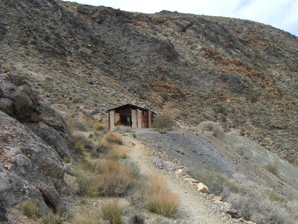 A small building located at the top of a tailing near a mine: