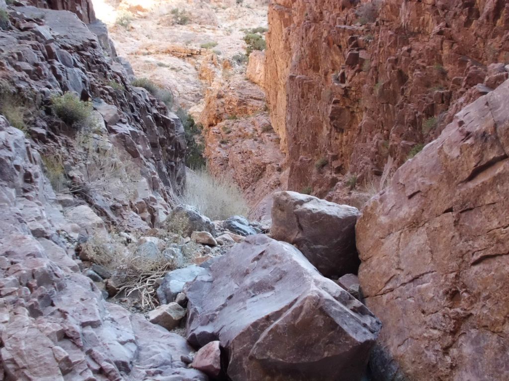 Large purple boulders which have fallen into the middle of the wash: