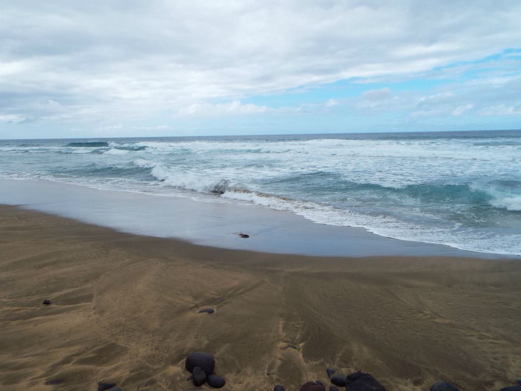 Just past some warning signs, the golden sand of Kalalau Beach becomes abundant: