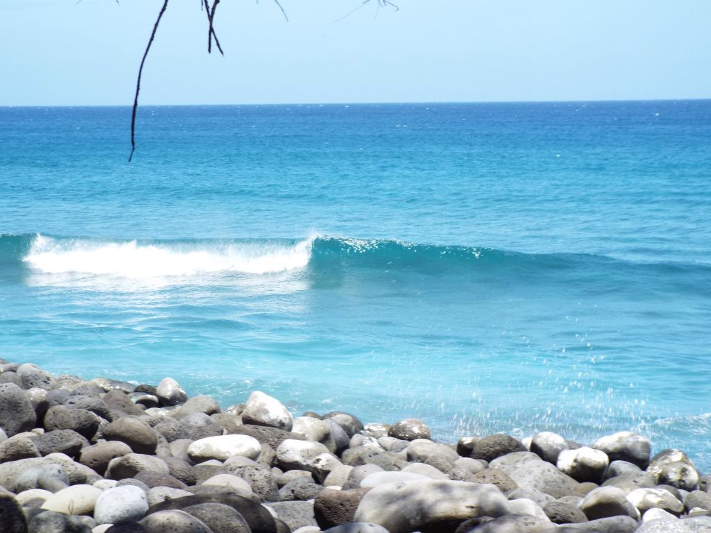 Looking out at a small wave breaking just off the shore: