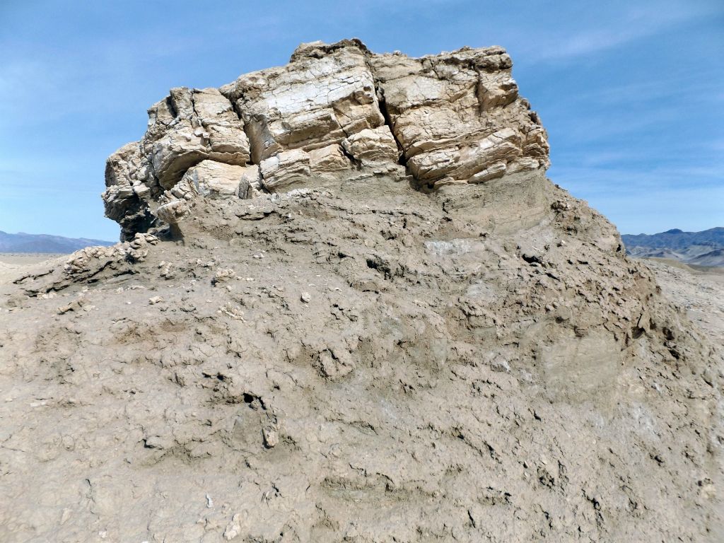 A rock formation rising up from the mud: