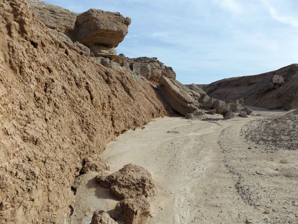 A huge overhanging rock which might soon join the others visible by falling down into the wash: