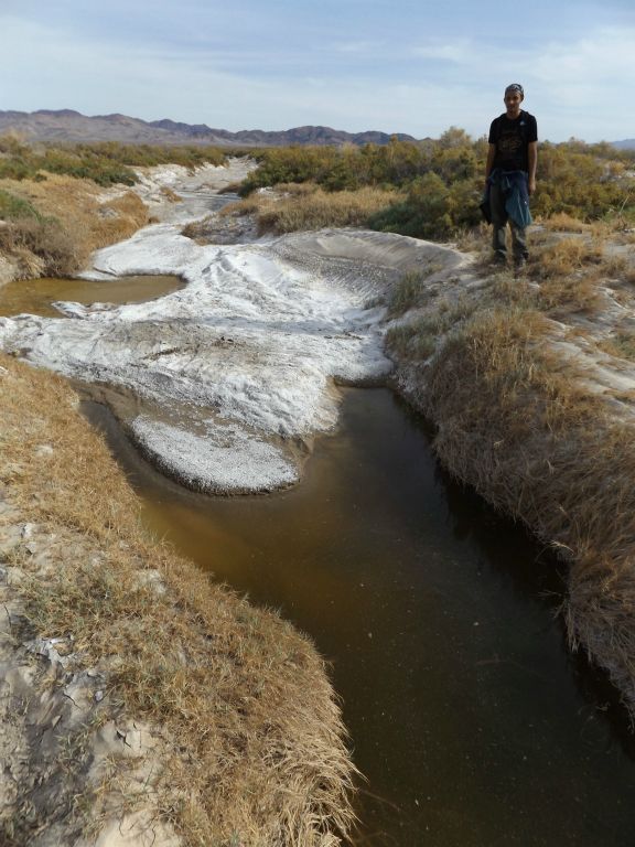 A picture of Jordan standing at the spot where Valley Spring's surface water begins:
