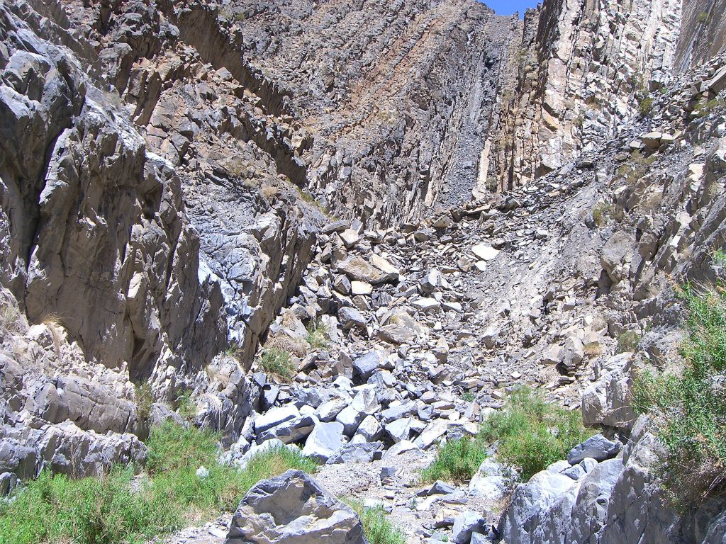 At the end of the upper Corridor, there is this boulder field and the canyon appears to end.  However, the canyon turns left with a high dry fall blocking further progress.  We do not recommend attempting to access Upper Corridor Canyon from here, as the ledge climb has exposure.  Instead, if you would like to see the upper canyon, the safest route is to enter from the head in Round Valley: