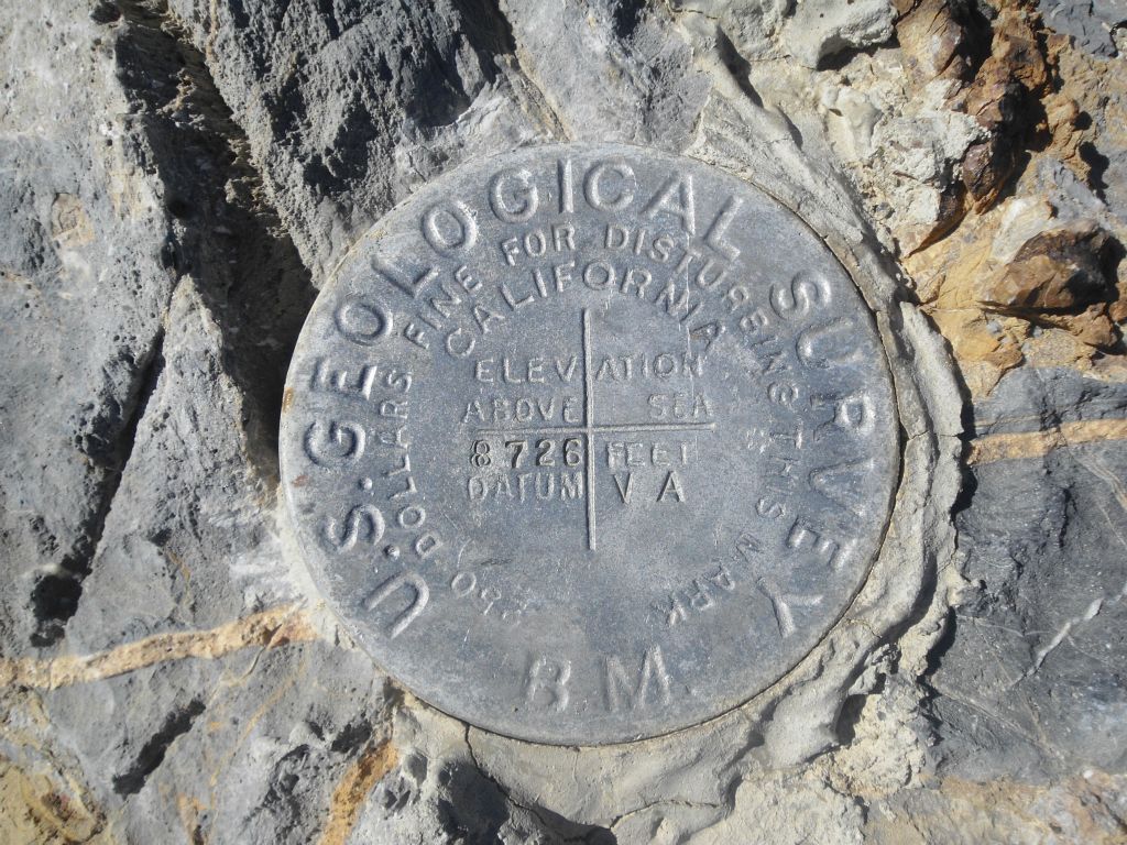 Two pictures of the geological survey markers on the summit: