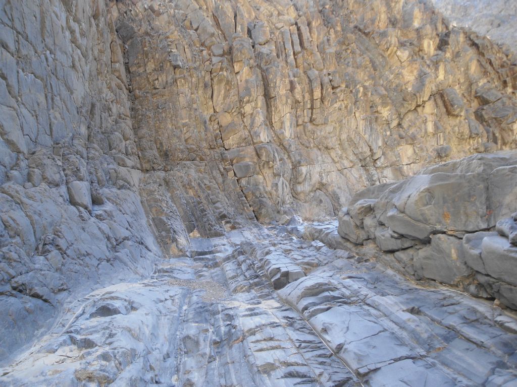 Two pictures showing a completely enclosed spot in the canyon with solid rock walls and floor: