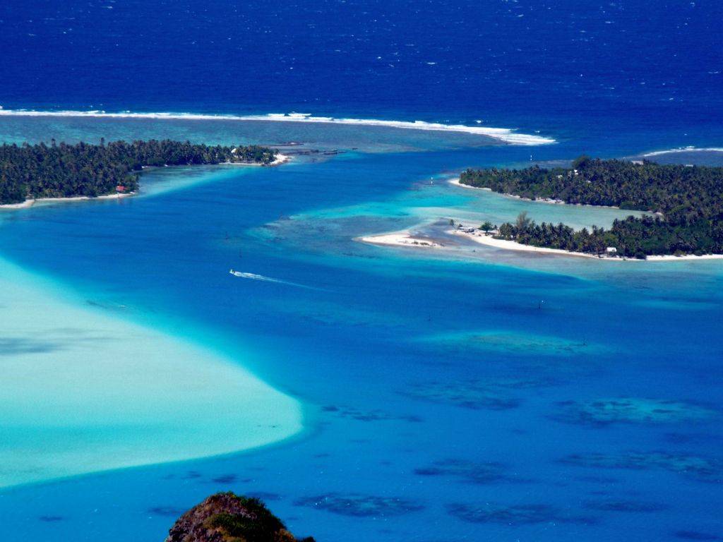 A zoomed view of the lagoon showing a boat speeding toward Onoiau Pass: