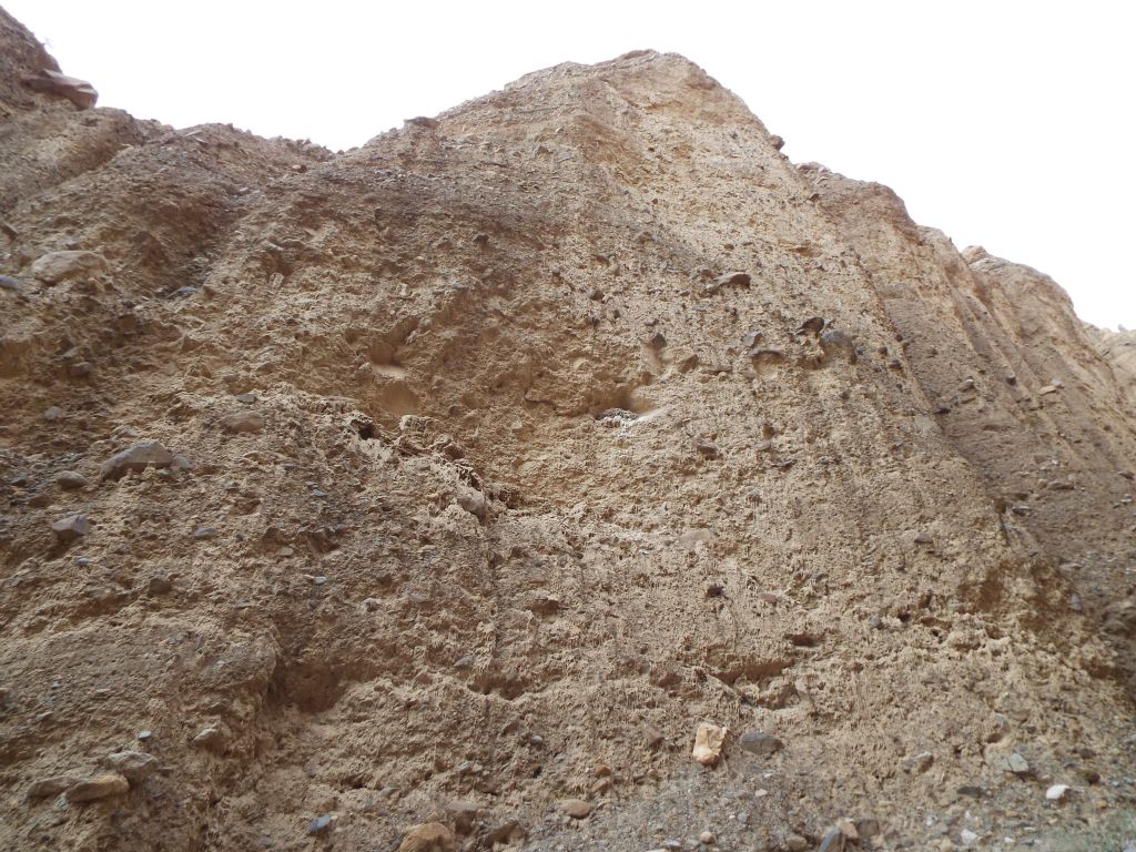 Towering vertical walls of conglomerate rock rose hundreds of feet straight up: