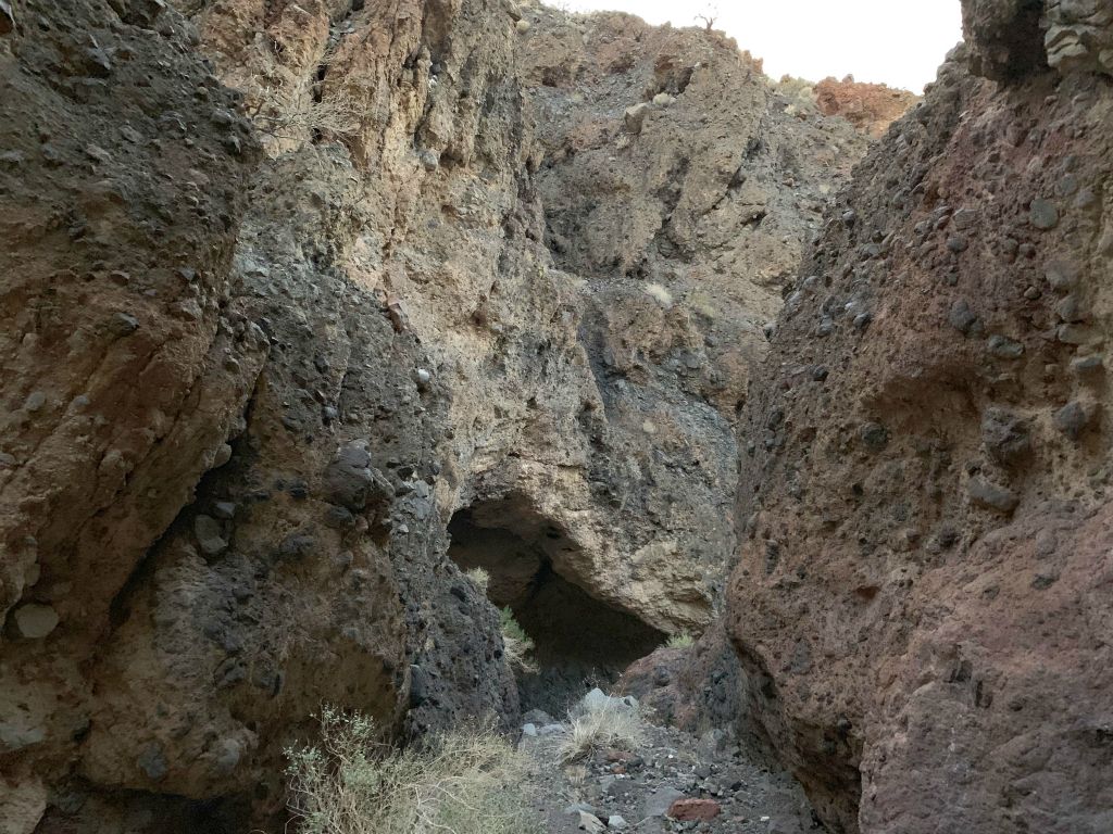 Note the overhang cave up ahead at the bottom of a large canyon wall: