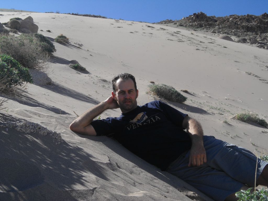 Two pictures of Steve relaxing on the sand of upper dune: