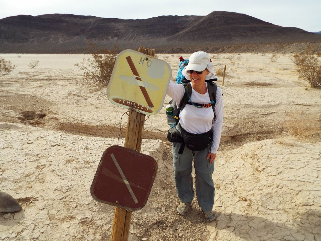 Debbie propping up another fallen sign which says that no vehicles are allowed on the lake bed: